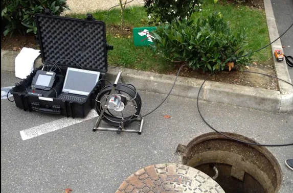 Matériel d'inspection vidéo de canalisation installé près d'un regard ouvert